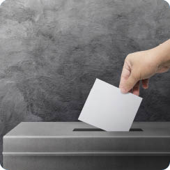 Hand holding ballot paper for election vote concept background 