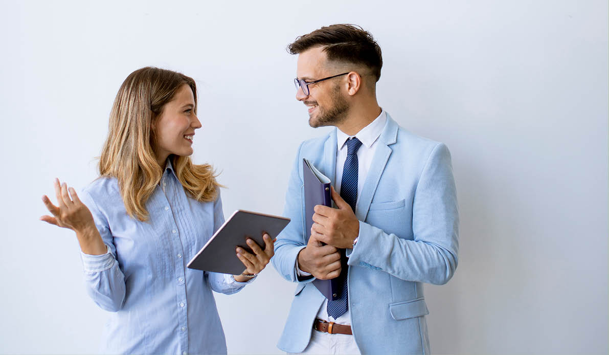 Young business people with digital tablet by the wall in the office