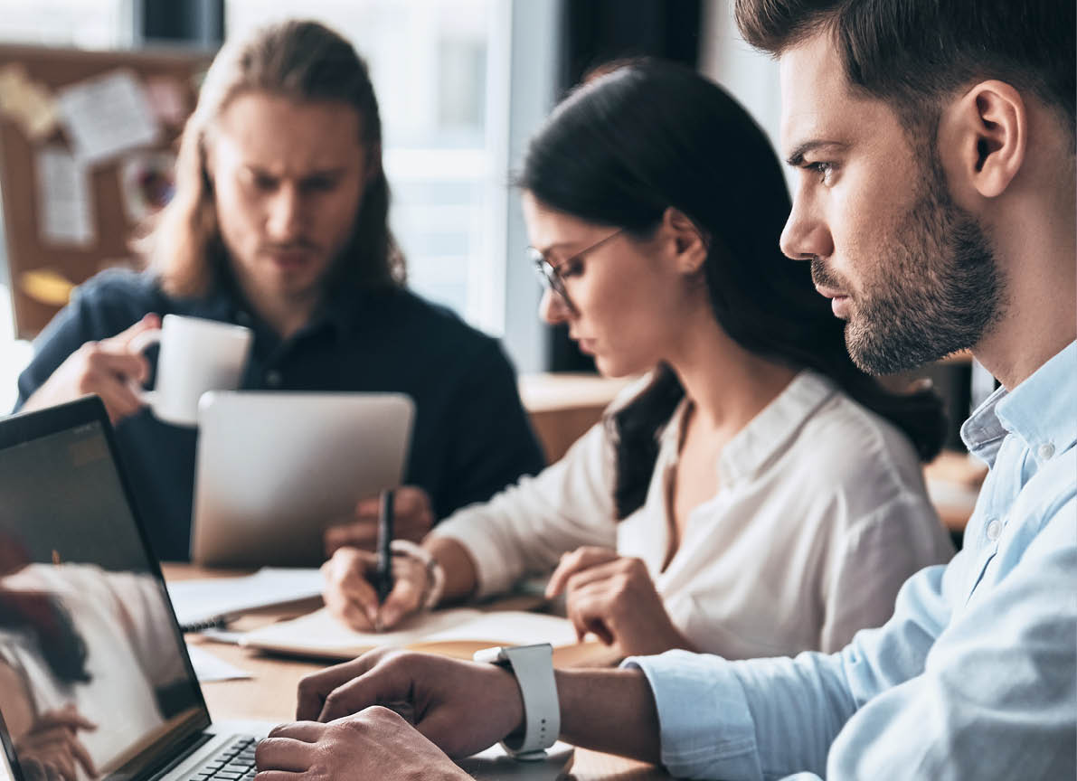 Creative office. Young modern colleagues in smart casual wear working while spending time in the office           