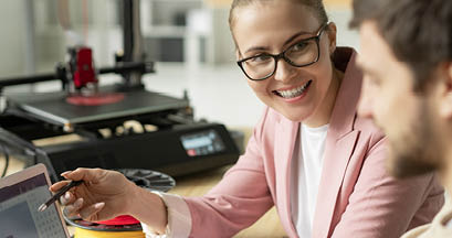 Young successful manager pointing at laptop display while looking at colleague during business discussion