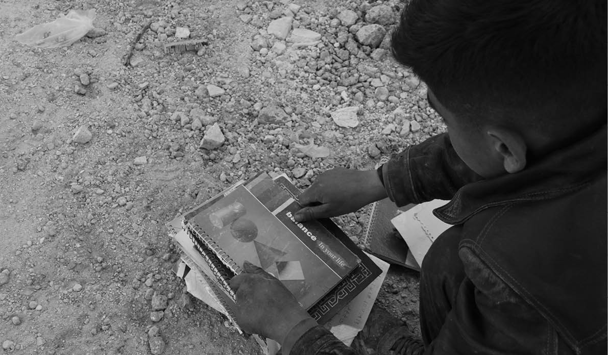 Child collects his books among the rubble after the collapse of his family's house in the earthquake that struck Syria and Turkey, killing tens of thousands.