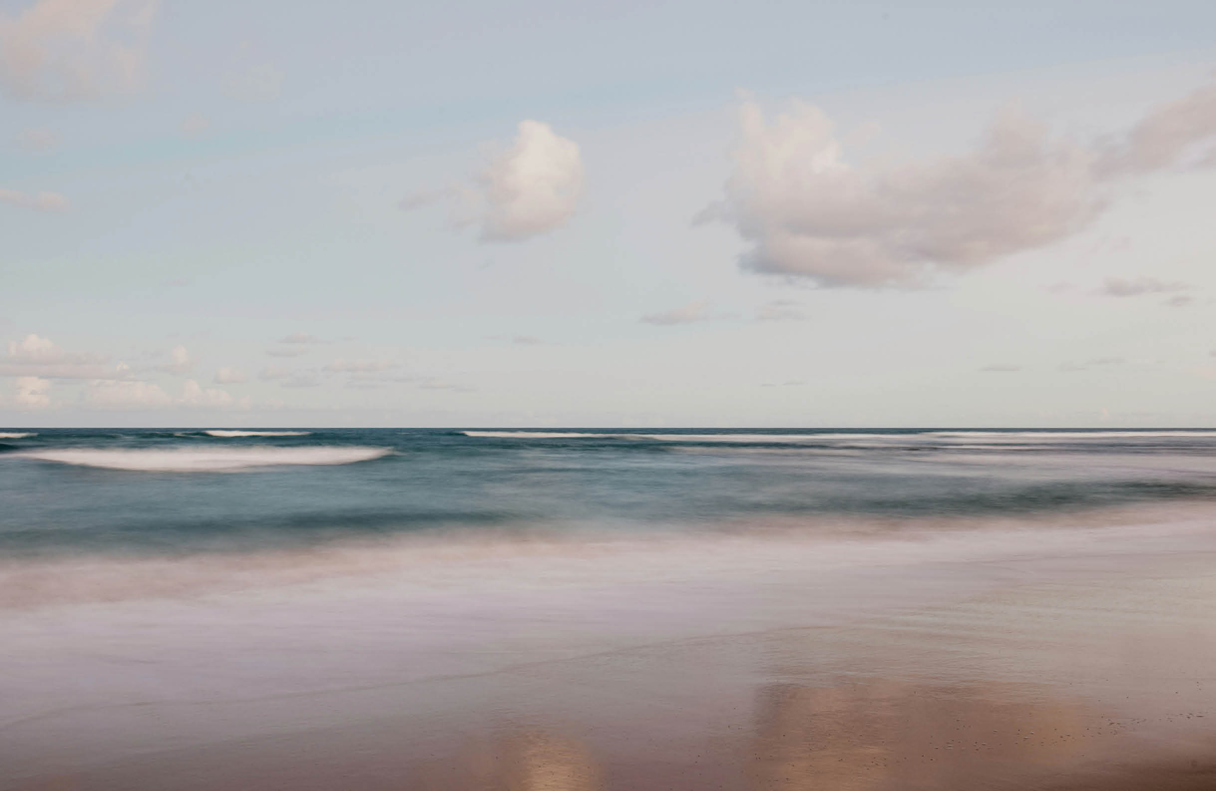 A beach scene with a person standing in the water. AI generated content