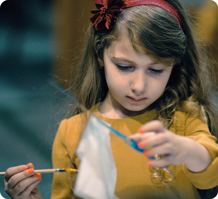 A young girl is holding a kite and a pair of scissors, preparing to cut the kite's tail. AI generated content
