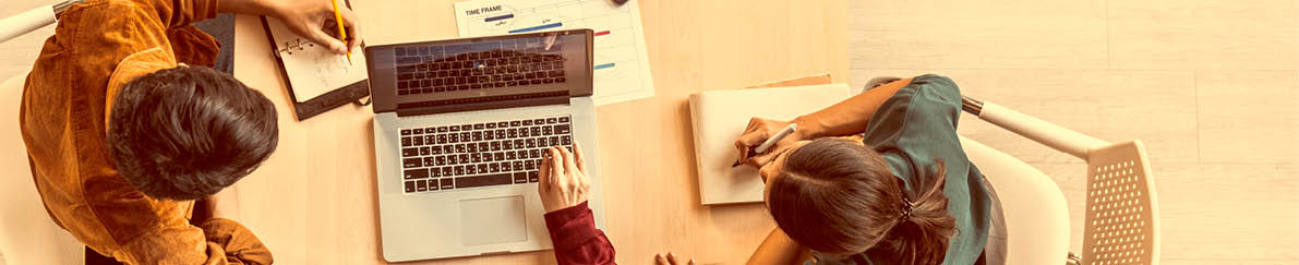 Young Asian business team work together in project brainstorm meeting, using laptop computer. Colleague coworker, startup office or people teamwork concept. Top view, banner size with copy space