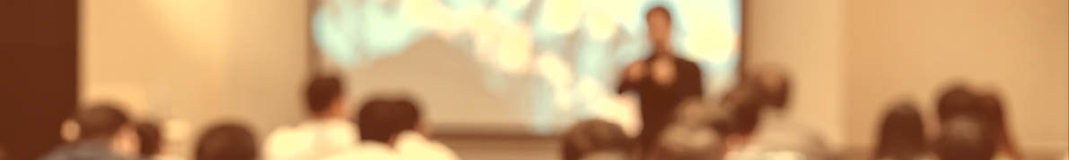 Speaker on the stage in front of the room with Rear view of Audience in put hand up acton for answer the question in the meeting or seminar meeting, business and education concept