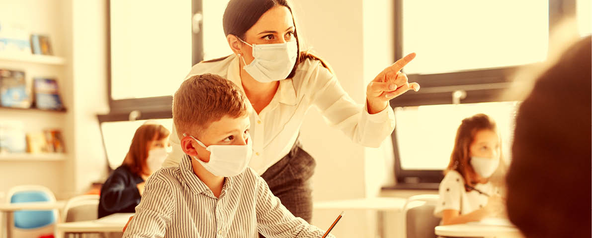Teacher and children with face mask back at school after covid-19 quarantine and lockdown.