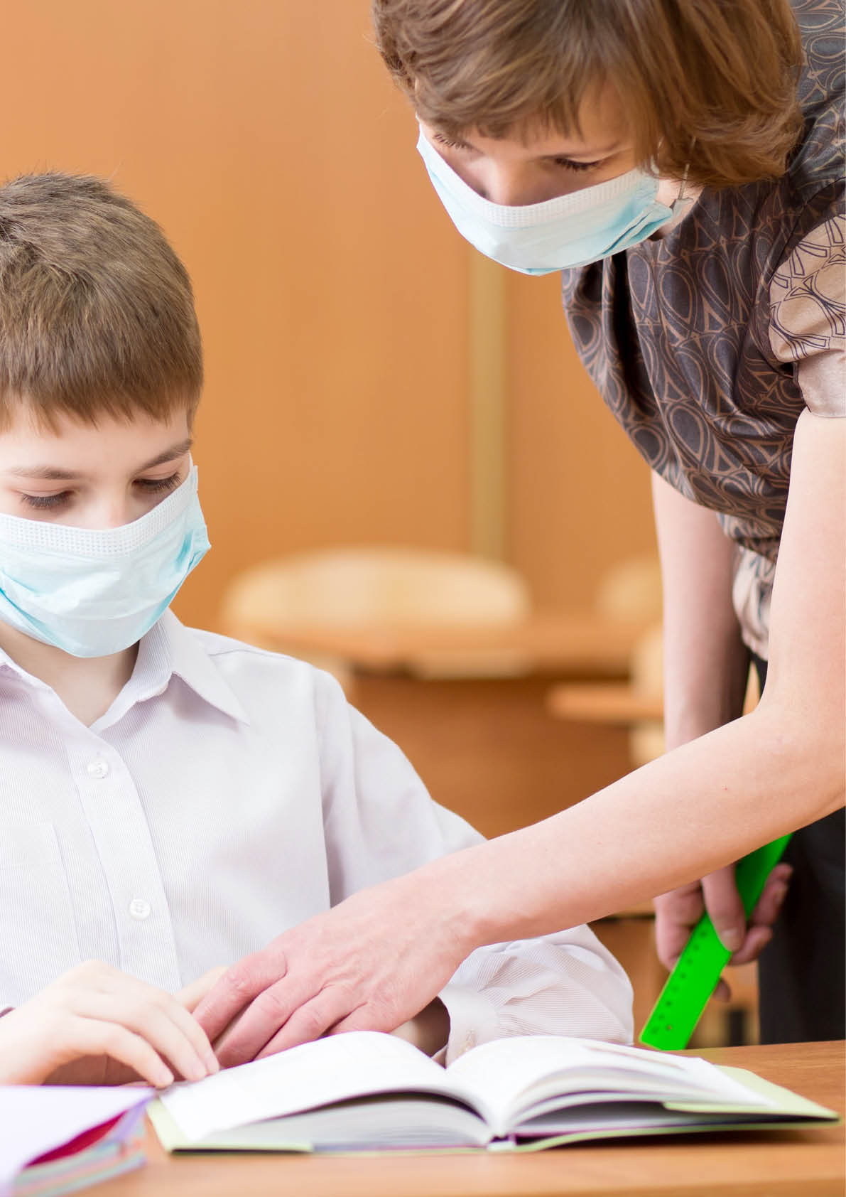 school children with protective masks against coronavirus at lesson in class room