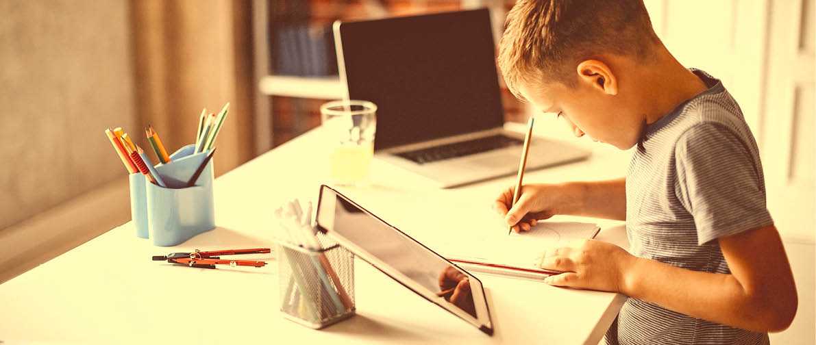 Kid learning for exam on digital tablet and laptop
