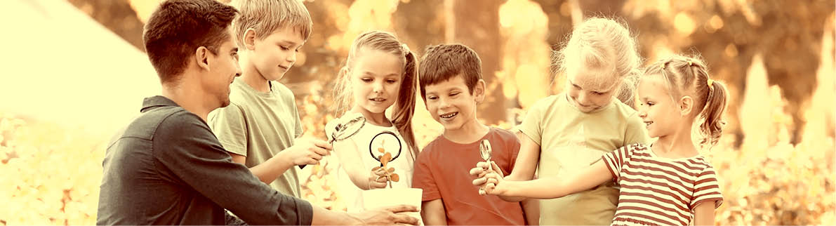 Group of children with teacher in park on sunny day