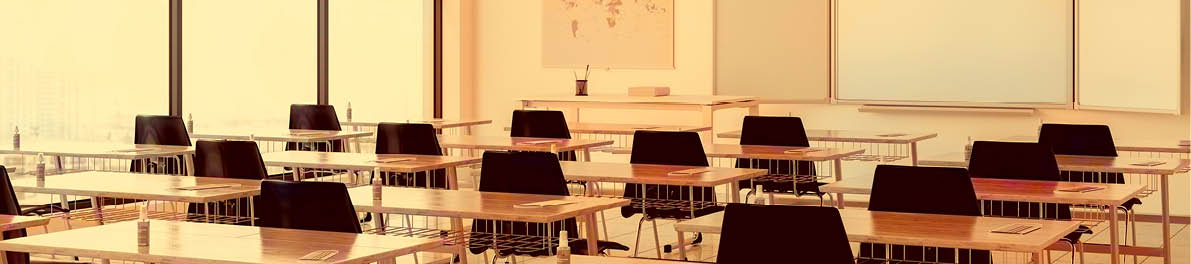 Protective Face Masks And Hand Sanitizers On The Desks According To New Normal Concept In An Empty Classroom.