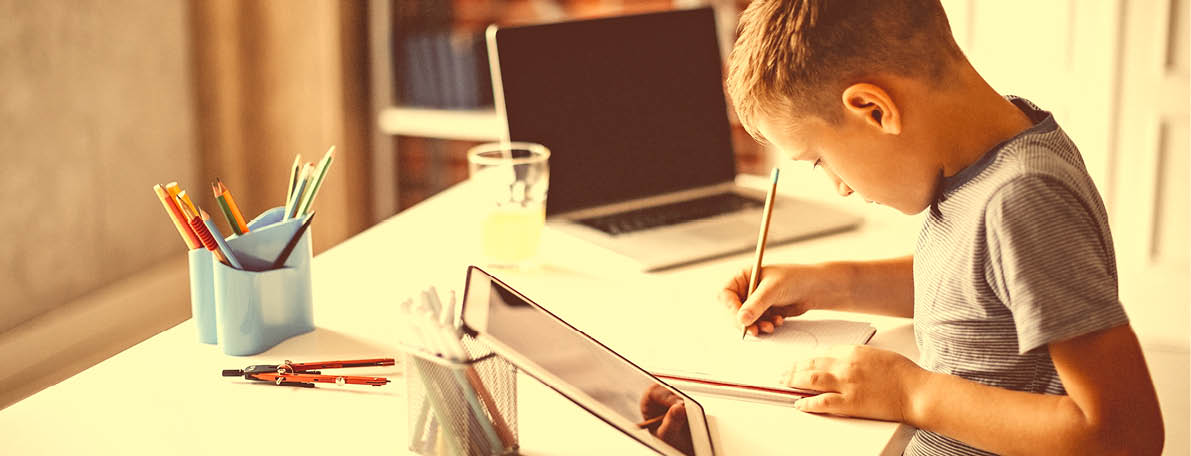 Kid learning for exam on digital tablet and laptop